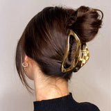 Chignon élégant avec grande pince à cheveux dorée Invisibobble Gold Luxe